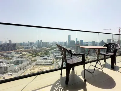 a balcony with a table and chairs and a view of a city at Luxurious new 1 bedroom with Balcony and New Building in Dubai