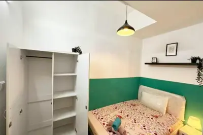a small bedroom with a green and white wall at Bagpack Double Partition Room in Tecom Near Metro in Dubai