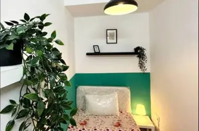 a bedroom with a chair and a green accent wall at Bagpack Double Partition Room in Tecom Near Metro in Dubai