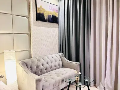 a living room with a couch and a table at Luxuriously Designed Spacious Studio In JVC in Dubai