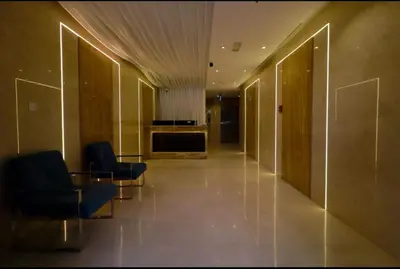 a hallway with two chairs and a table in a building at Luxuriously Designed Spacious Studio In JVC in Dubai