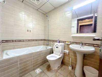 a bathroom with a tub and a toilet and a sink at Adventurers Partition Room in Barsha Heights in Dubai