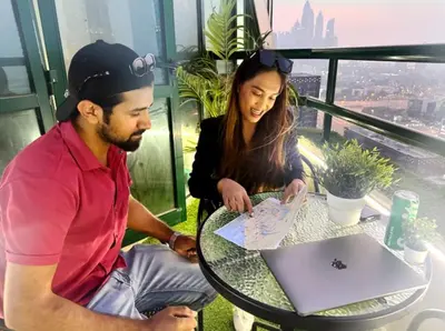 a man and a woman sitting at a table with a laptop at Adventurers Partition Room in Barsha Heights in Dubai