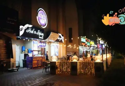 a restaurant on a street at night with lights at Adventurers Partition Room in Barsha Heights in Dubai