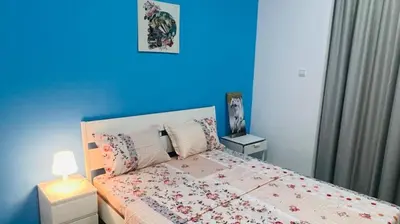 a bedroom with a bed with a blue wall at Newly Furnished Room in Barsha 1 Near MOE in Dubai