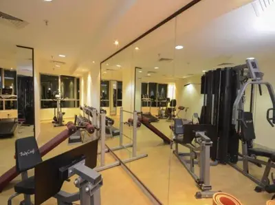 a gym with a mirror and lots of machines at Newly Furnished Room in Barsha 1 Near MOE in Dubai
