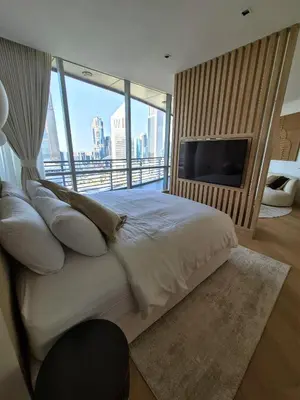 a bedroom with a large bed and a television at 85m2 En Suite, DIFC in Dubai