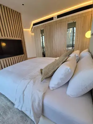 a bedroom with a large bed with white pillows at 85m2 En Suite, DIFC in Dubai