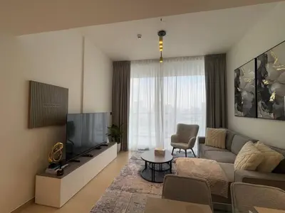 a living room with a couch and a television at New 1br Apt Jvc Pool View, Balcony & Parking in Dubai
