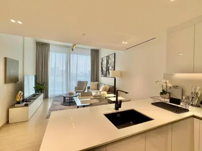 a kitchen and living room with a couch and a table at New 1br Apt Jvc Pool View, Balcony & Parking in Dubai