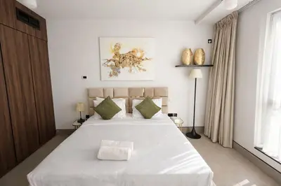 a bedroom with a large white bed with green pillows at Modern Marina Escape 4BR Family Retreat at JBR in Dubai