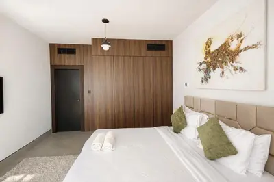 a bedroom with a bed and a wooden door at Modern Marina Escape 4BR Family Retreat at JBR in Dubai