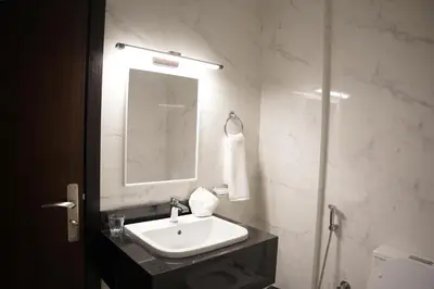 a white bathroom with a sink and a mirror at Ista Vacation Homes Rental LLC KARAMA in Dubai