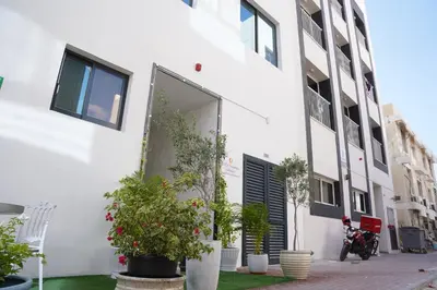 a white building with potted plants in front of it at Ista Vacation Homes Rental LLC KARAMA in Dubai