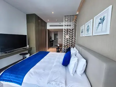 a bedroom with a large bed with a blue pillow at Damac Maison Prive - Blue Ocean Holiday Homes in Dubai