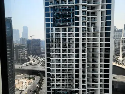 a view of a tall white building in a city at Damac Maison Prive - Blue Ocean Holiday Homes in Dubai