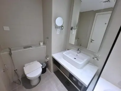 a bathroom with a sink and a toilet and a mirror at Damac Maison Prive - Blue Ocean Holiday Homes in Dubai