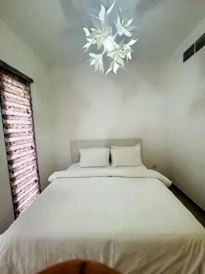 a bedroom with a large bed with a chandelier above it at 02 Bedroom Apartment in Townsquare in Dubai
