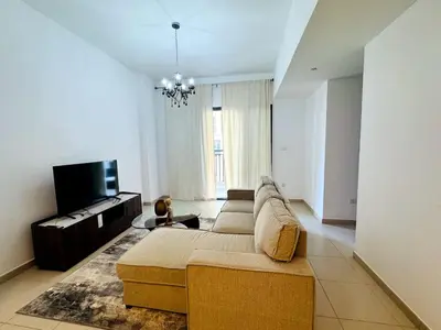 a living room with a couch and a tv at 02 Bedroom Apartment in Townsquare in Dubai