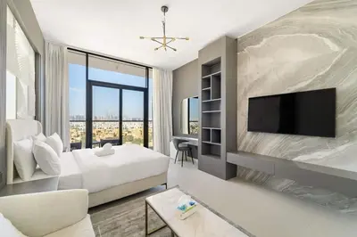 a hotel room with a bed and a flat screen tv at Charming new studio with pool and gym in Al Furjan in Dubai