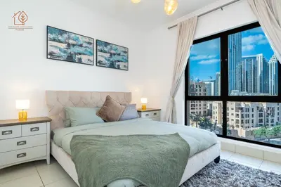 a bedroom with a bed and a large window at Cozy Old Town 2-Bed Apartment with Burj Khalifa Views 202RH-2 in Dubai