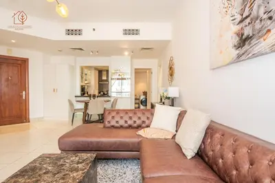 a living room with a brown leather couch at Cozy Old Town 2-Bed Apartment with Burj Khalifa Views 202RH-2 in Dubai