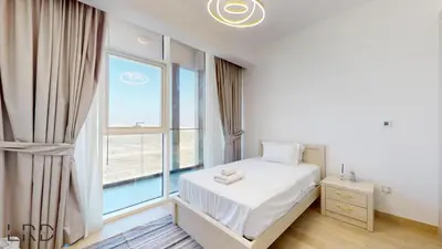 a bedroom with a bed and a large window at Spacious 3BR Apartment in Dubai