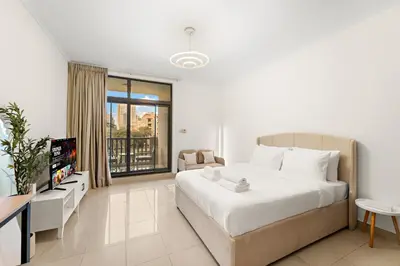 a bedroom with a large bed and a tv in it at Cozy Studio with Scenic Canal Views in Dubai