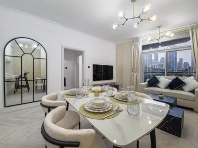 a living room with a white table and chairs at Luxury 2-bed Condo Full Burj Khalifa Lights View! in Dubai