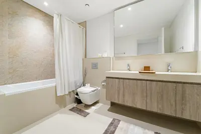 a bathroom with a sink and a toilet and a tub at Elegant 2BR in Downtown Dubai l Walk to Dubai Mall in Dubai