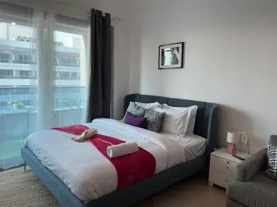 a bedroom with a large bed with a window at Cozy Studio- Dubai Marina in Dubai