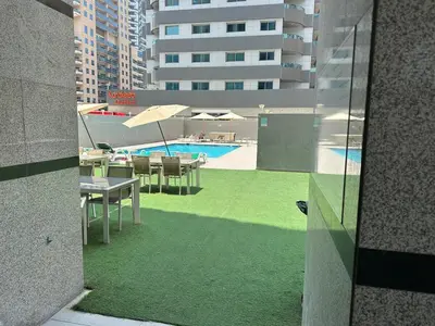 a view of a swimming pool with tables and chairs at Cozy Studio- Dubai Marina in Dubai