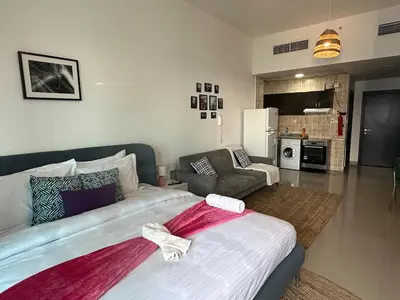 a bedroom with a large bed and a living room at Cozy Studio- Dubai Marina in Dubai