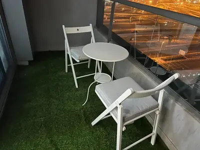 two chairs and a table on a balcony at Studio Apartment- Dubai Marina in Dubai