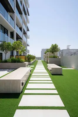 an office building with green grass and benches at Modern & Elegant 1br Apartment In Jvc in Dubai