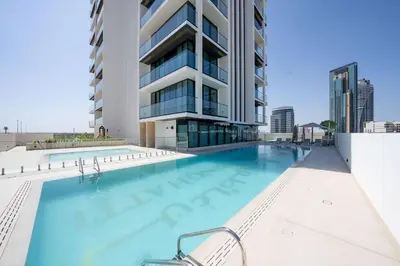 a swimming pool in front of a building at Chic Urban 1br In Jvc With Modern Amenities in Dubai