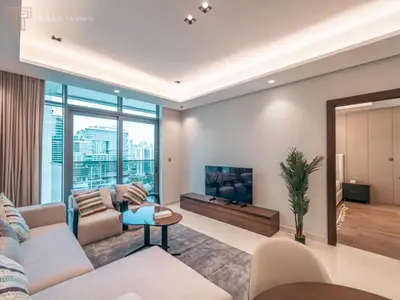 a living room with a couch and a tv at Stunning One Bed Apartment In Luxury Tower in Dubai