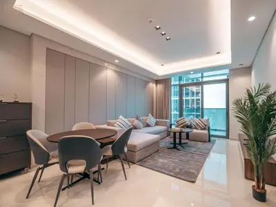 a living room with a table and chairs and a couch at Stunning One Bed Apartment In Luxury Tower in Dubai