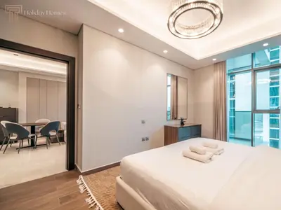 a bedroom with a large bed and a dining room at Stunning One Bed Apartment In Luxury Tower in Dubai