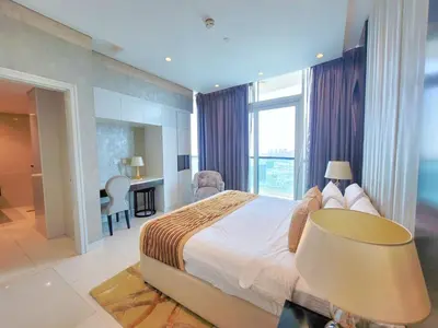 a large bedroom with a large bed and a desk at Damac Upper Crest - Blue Ocean Holiday Homes in Dubai