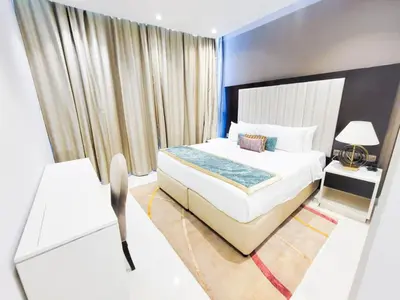 a bedroom with a large white bed and a window at Damac Upper Crest - Blue Ocean Holiday Homes in Dubai