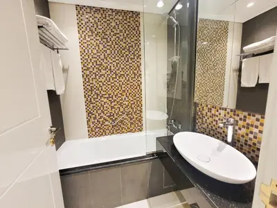 a bathroom with a sink and a shower at Damac Upper Crest - Blue Ocean Holiday Homes in Dubai