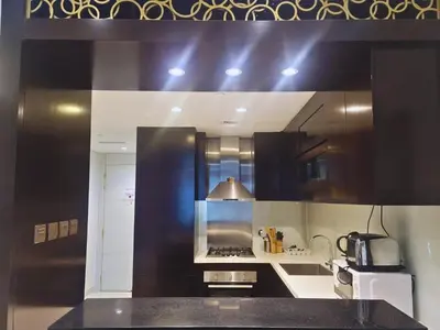 a kitchen with a black and white counter top at Damac Upper Crest - Blue Ocean Holiday Homes in Dubai
