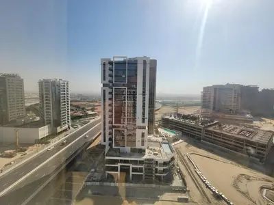 a tall building is under construction next to a highway at Damac Park Central - Blue Ocean Holiday Homes in Dubai