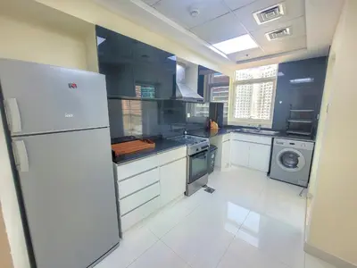 a kitchen with a refrigerator and a washing machine at Damac Park Central - Blue Ocean Holiday Homes in Dubai