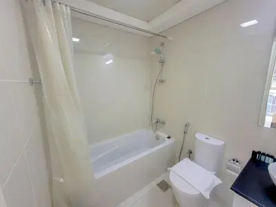 a bathroom with a tub and a toilet and a sink at Damac Park Central - Blue Ocean Holiday Homes in Dubai