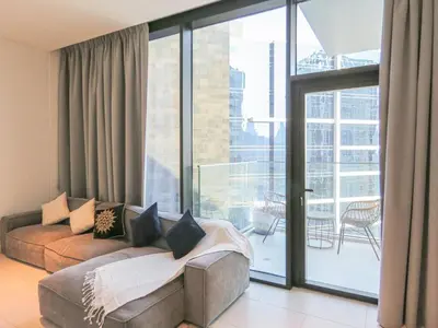 a living room with a couch and a large window at Luxury Living , Beautiful Layout in Dubai