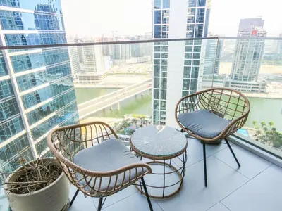 a balcony with three chairs and a table on a building at Luxury Living , Beautiful Layout in Dubai