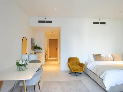 a bedroom with a bed and a desk and a chair at Luxury Living , Beautiful Layout in Dubai