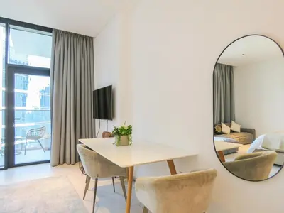 a living room with a table and a mirror at Luxury Living , Beautiful Layout in Dubai